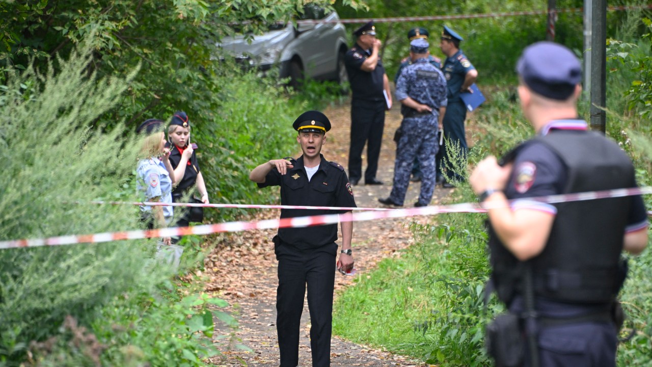 Police officers work at the site where a Ukrainian drone targeting the Russian capital was downed by air defence system, in western Moscow on August 11, 2023. (Photo by Alexander NEMENOV / AFP)