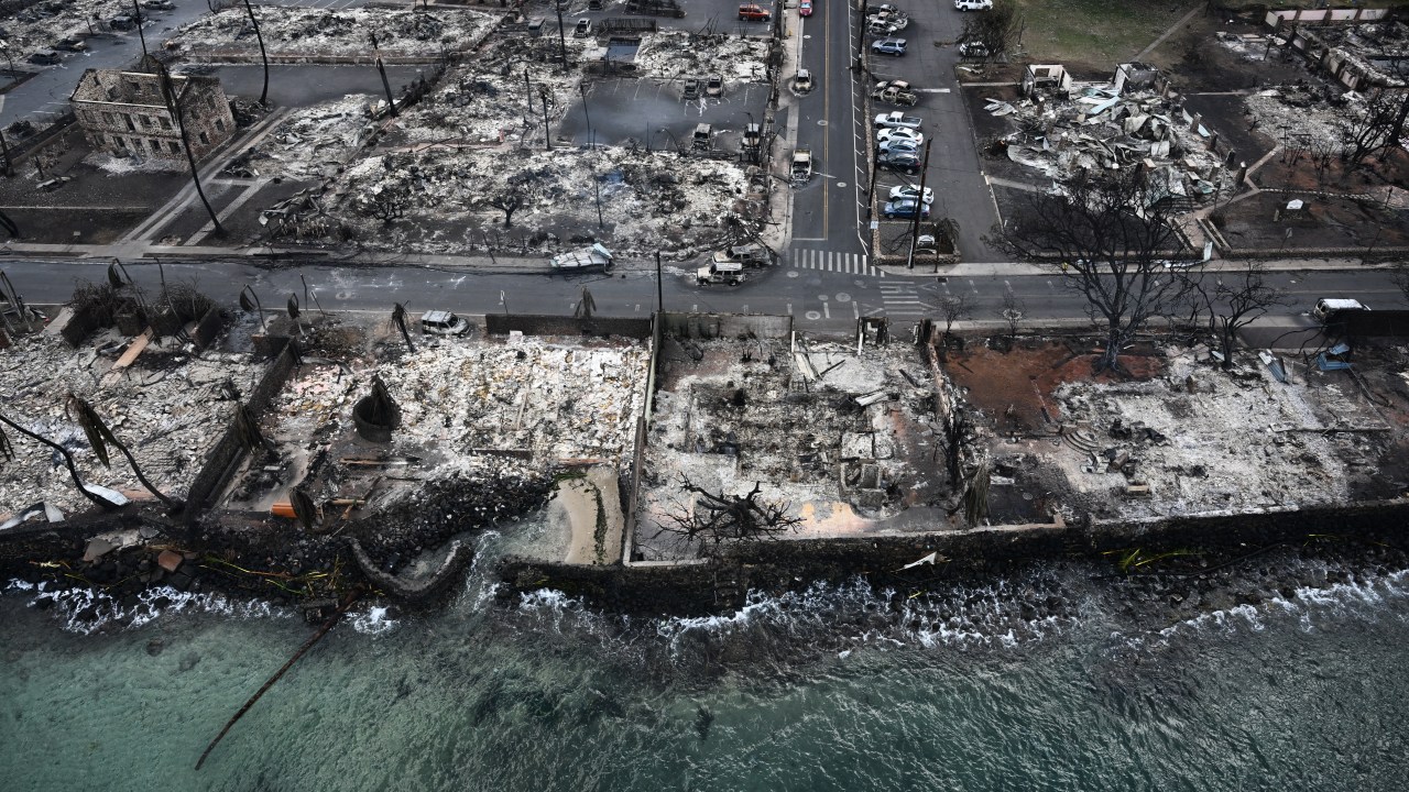 An aerial image taken on August 10, 2023 shows destroyed homes and buildings burned to the ground in Lahaina along the Pacific Ocean in the aftermath of wildfires in western Maui, Hawaii. A terrifying wildfire that left a historic Hawaiian town in charred ruins has killed at least 55 people, authorities said on August 10, making it one of the deadliest disasters in the US state's history. (Photo by Patrick T. Fallon / AFP)