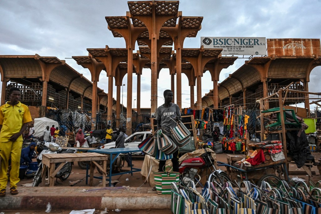 A vendor sells bags outside a market in Niamey on August 14, 2023. (Photo by AFP)