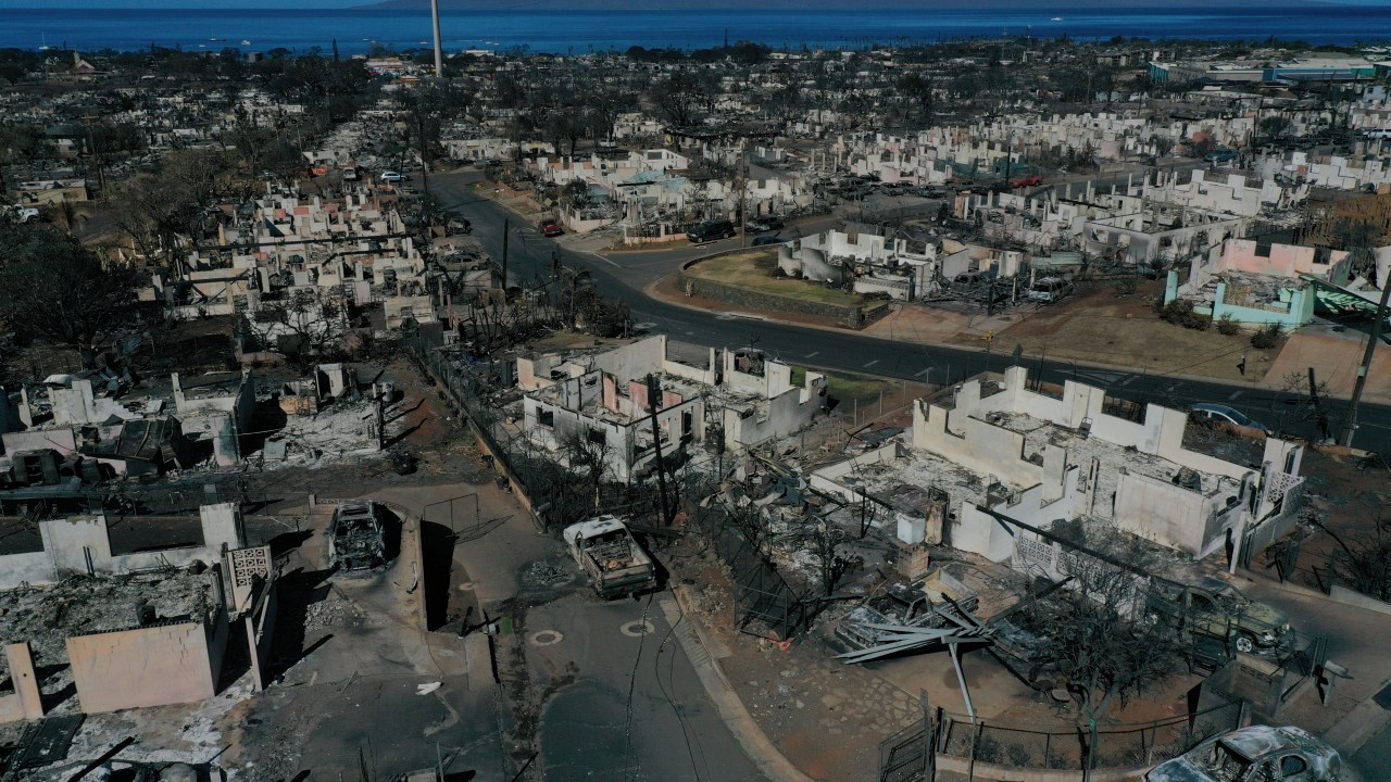 An aerial image shows destroyed homes and vehicles after a wind driven wildfire burned from the hills through neighborhoods to the Pacific Ocean, as seen in the aftermath of the Maui wildfires in Lahaina, Hawaii, on August 17, 2023. Embattled officials in Hawaii who have been criticized for the lack of warnings as a deadly wildfire ripped through a town insisted on August 16 that sounding emergency sirens would not have saved lives. At least 110 people died when the inferno levelled Lahaina last week on the island of Maui, with some residents not aware their town was at risk until they saw flames for themselves. (Photo by Patrick T. Fallon / AFP)