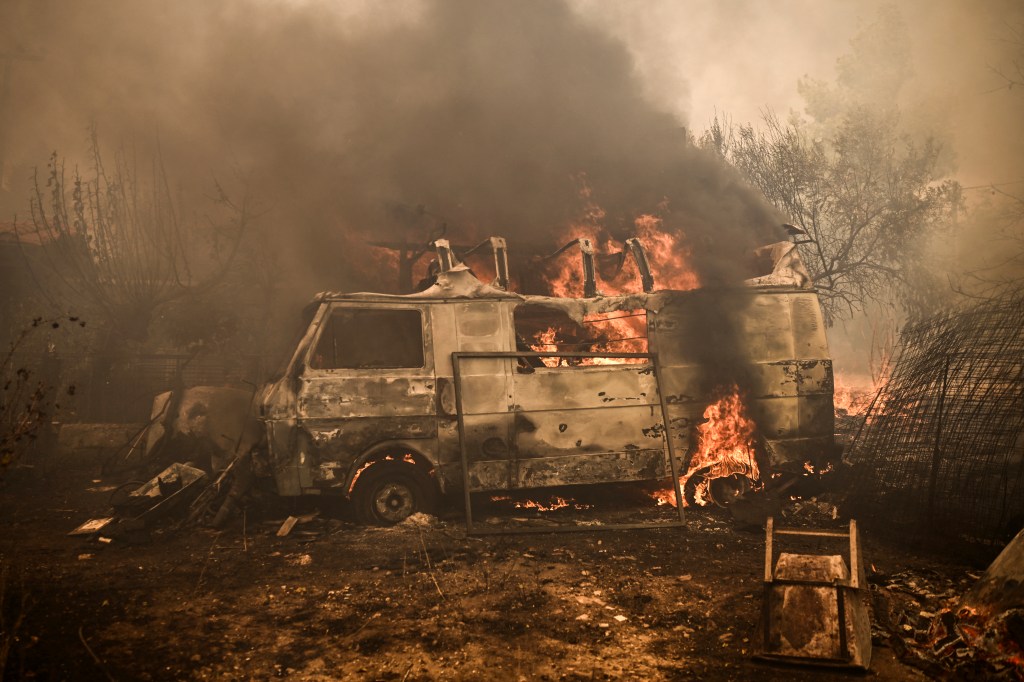 This photograph taken on August 23, 2023 shows a vehicle burning as a wildfire spreads in Acharnes, north of Athens. Greek firefighters on August 23, 2023 struggled to contain uncontrolled fires throughout the country for a fifth day, several of them bordering an acrid, smoke-filled Athens. (Photo by Angelos Tzortzinis / AFP) / The erroneous mention[s] appearing in the metadata of this photo by Angelos Tzortzinis has been modified in AFP systems in the following manner: [Acharnes] instead of [Archanes]. Please immediately remove the erroneous mention[s] from all your online services and delete it (them) from your servers. If you have been authorized by AFP to distribute it (them) to third parties, please ensure that the same actions are carried out by them. Failure to promptly comply with these instructions will entail liability on your part for any continued or post notification usage. Therefore we thank you very much for all your attention and prompt action. We are sorry for the inconvenience this notification may cause and remain at your disposal for any further information you may require.