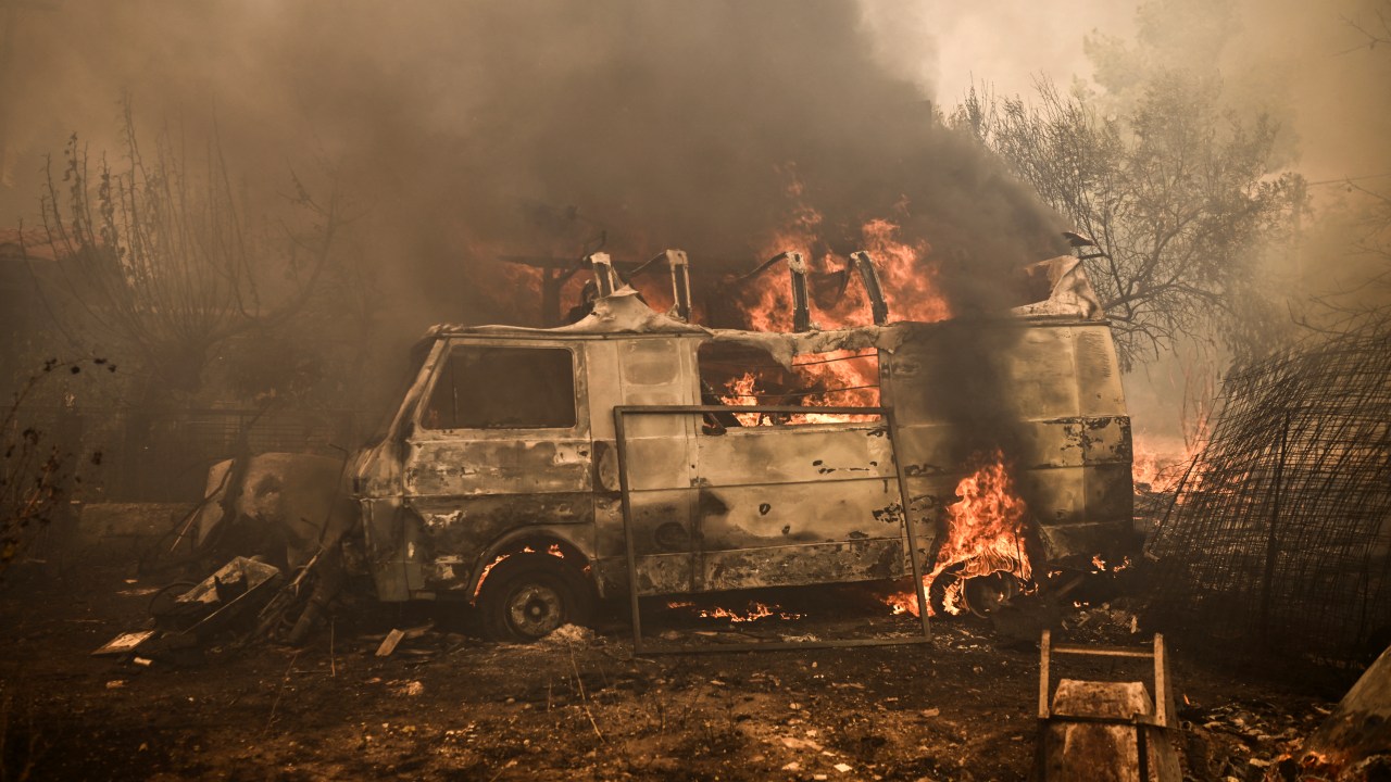 This photograph taken on August 23, 2023 shows a vehicle burning as a wildfire spreads in Acharnes, north of Athens. Greek firefighters on August 23, 2023 struggled to contain uncontrolled fires throughout the country for a fifth day, several of them bordering an acrid, smoke-filled Athens. (Photo by Angelos Tzortzinis / AFP) / The erroneous mention[s] appearing in the metadata of this photo by Angelos Tzortzinis has been modified in AFP systems in the following manner: [Acharnes] instead of [Archanes]. Please immediately remove the erroneous mention[s] from all your online services and delete it (them) from your servers. If you have been authorized by AFP to distribute it (them) to third parties, please ensure that the same actions are carried out by them. Failure to promptly comply with these instructions will entail liability on your part for any continued or post notification usage. Therefore we thank you very much for all your attention and prompt action. We are sorry for the inconvenience this notification may cause and remain at your disposal for any further information you may require.
