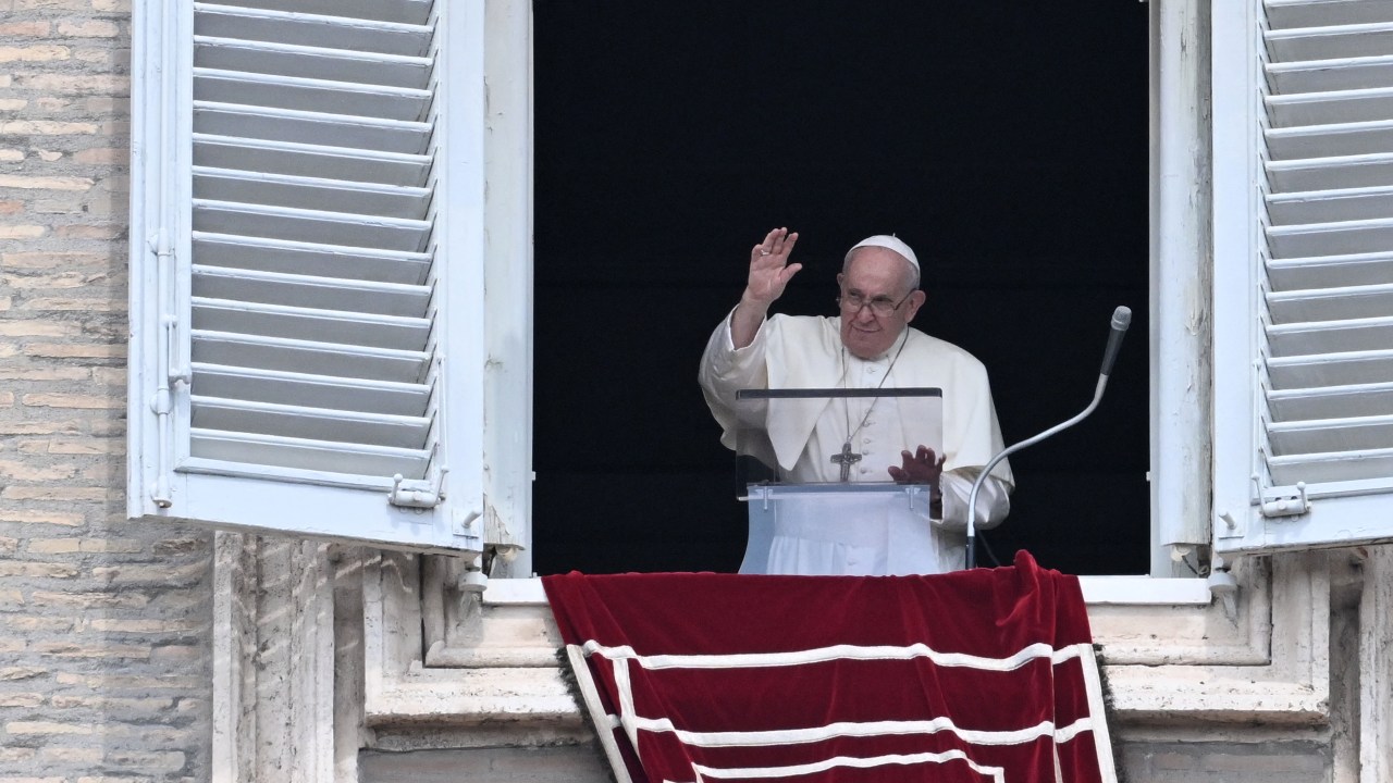 Pope Francis waves to the crowd from the window of the apostolic palace overlooking St. Peter's square during the weekly Angelus prayer on August 27, 2023 in The Vatican. (Photo by Tiziana FABI / AFP)