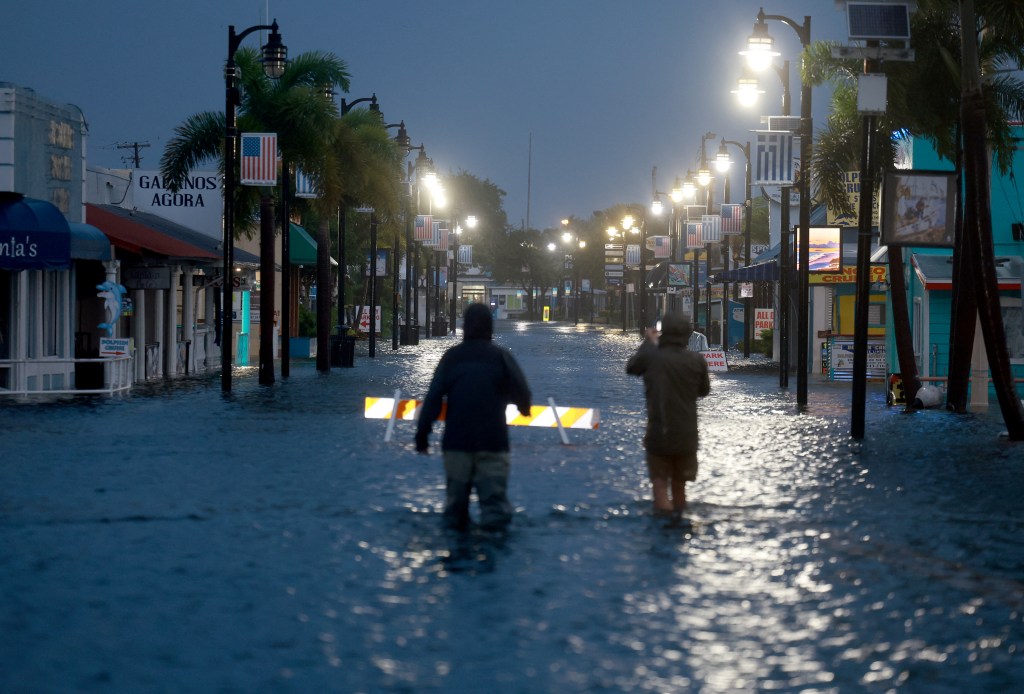 TARPON SPRINGS, FLORIDA - AUGUST 30: Reporters wade through flood waters as it inundates the downtown area after Hurricane Idalia passed offshore on August 30, 2023 in Tarpon Springs, Florida. Hurricane Idalia is hitting the Big Bend area of Florida. Joe Raedle/Getty Images/AFP (Photo by JOE RAEDLE / GETTY IMAGES NORTH AMERICA / Getty Images via AFP)