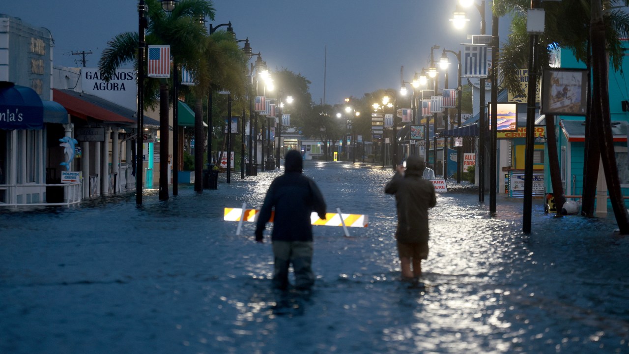 TARPON SPRINGS, FLORIDA - AUGUST 30: Reporters wade through flood waters as it inundates the downtown area after Hurricane Idalia passed offshore on August 30, 2023 in Tarpon Springs, Florida. Hurricane Idalia is hitting the Big Bend area of Florida. Joe Raedle/Getty Images/AFP (Photo by JOE RAEDLE / GETTY IMAGES NORTH AMERICA / Getty Images via AFP)