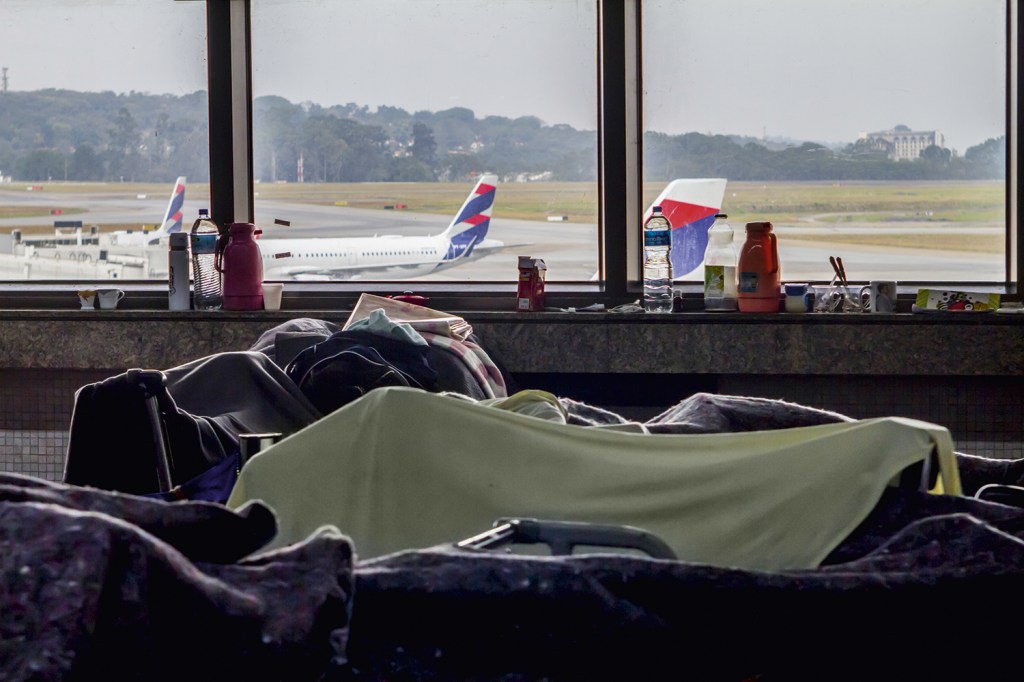 ACAMPAMENTO - Saguão do aeroporto: famílias aguardam ali por abrigo