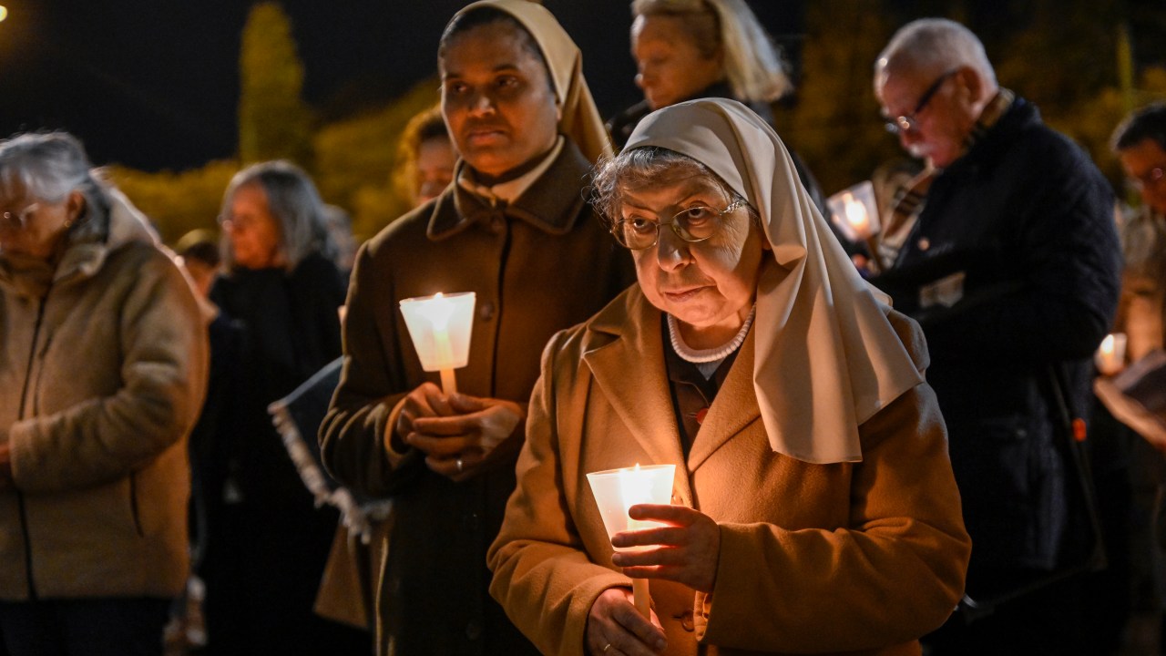 Duas freiras se juntam aos fiéis portugueses segurando velas durante uma vigília pelas vítimas de abuso sexual na Igreja fora do Mosteiro dos Jerônimos em Lisboa, em Portugal. 22/02/2023