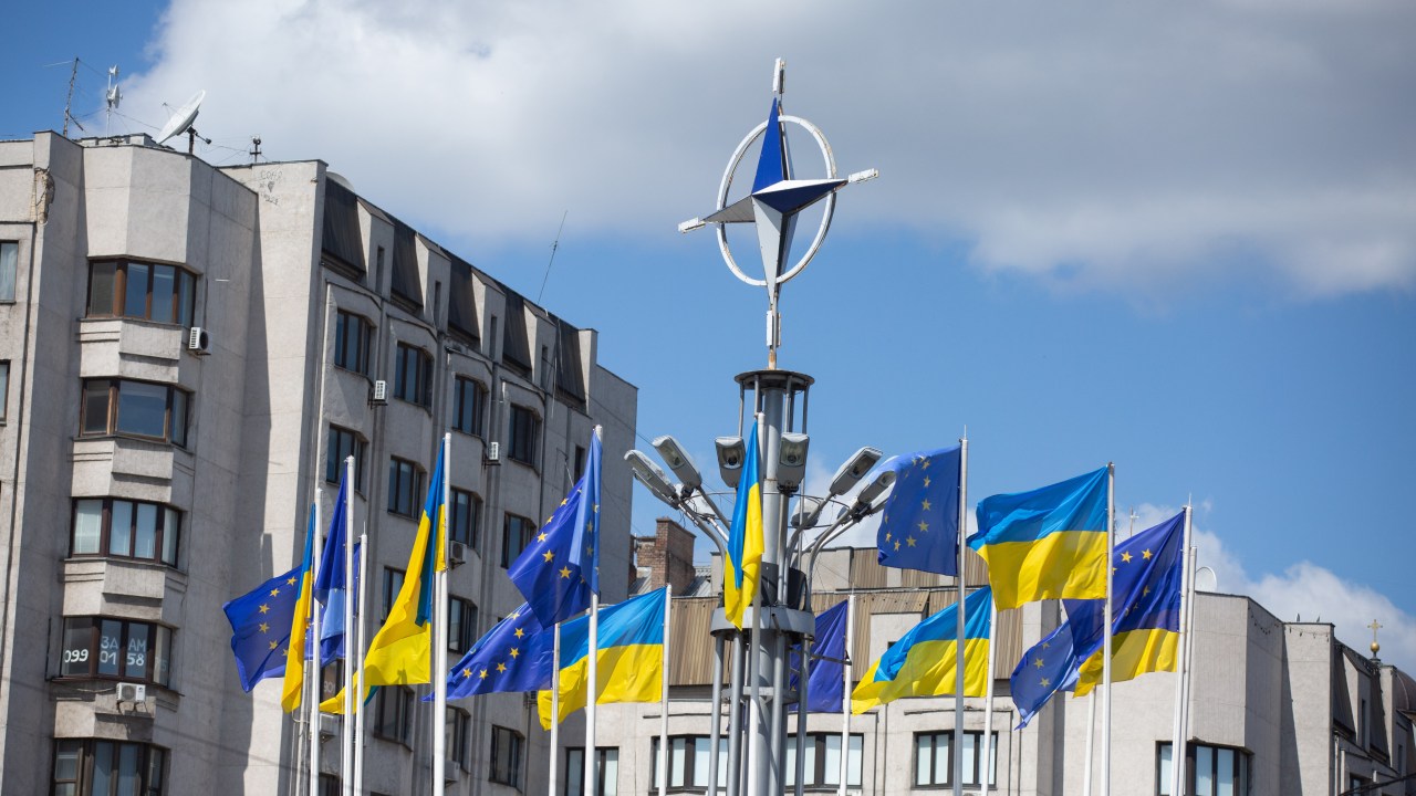 KYIV, UKRAINE - 2023/07/12: National flags of Ukraine and European Union rise in front of the NATO emblem in central Kyiv during the NATO summit in Vilnius. (Photo by Oleksii Chumachenko/SOPA Images/LightRocket via Getty Images)