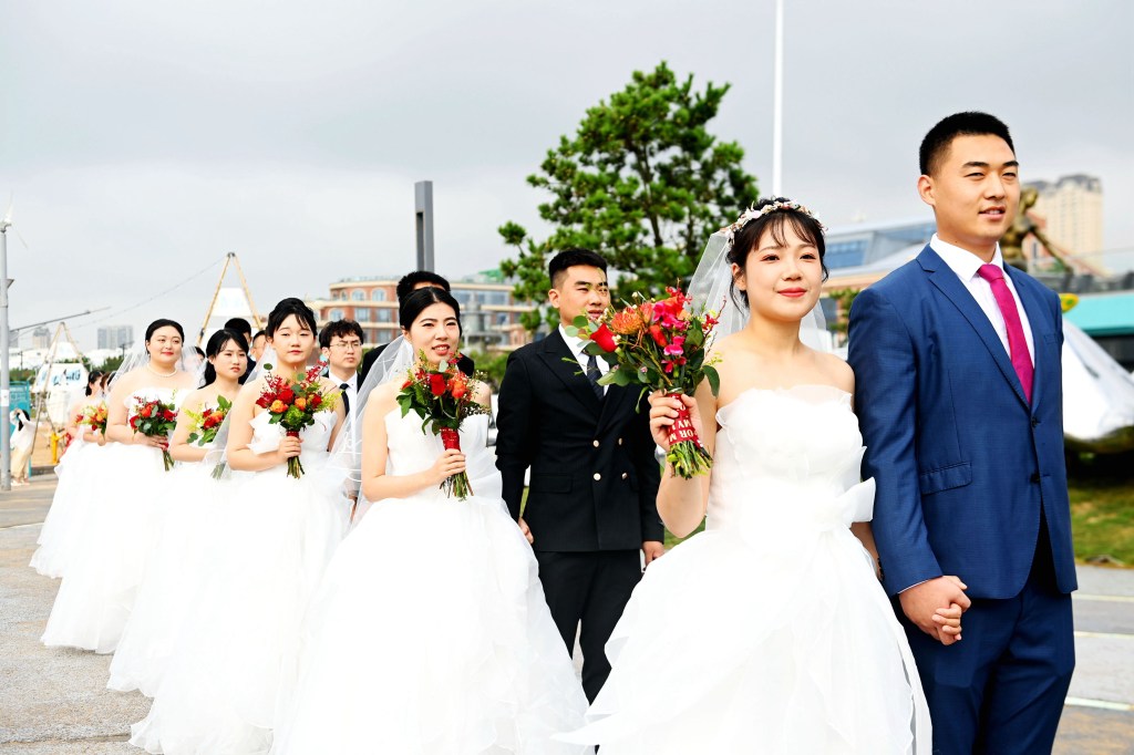 Couples attend a collective wedding at Love Bay, Golden Beach Beer City in Qingdao, Shandong province, China, August 22, 2023. (Photo by Costfoto/NurPhoto via Getty Images)