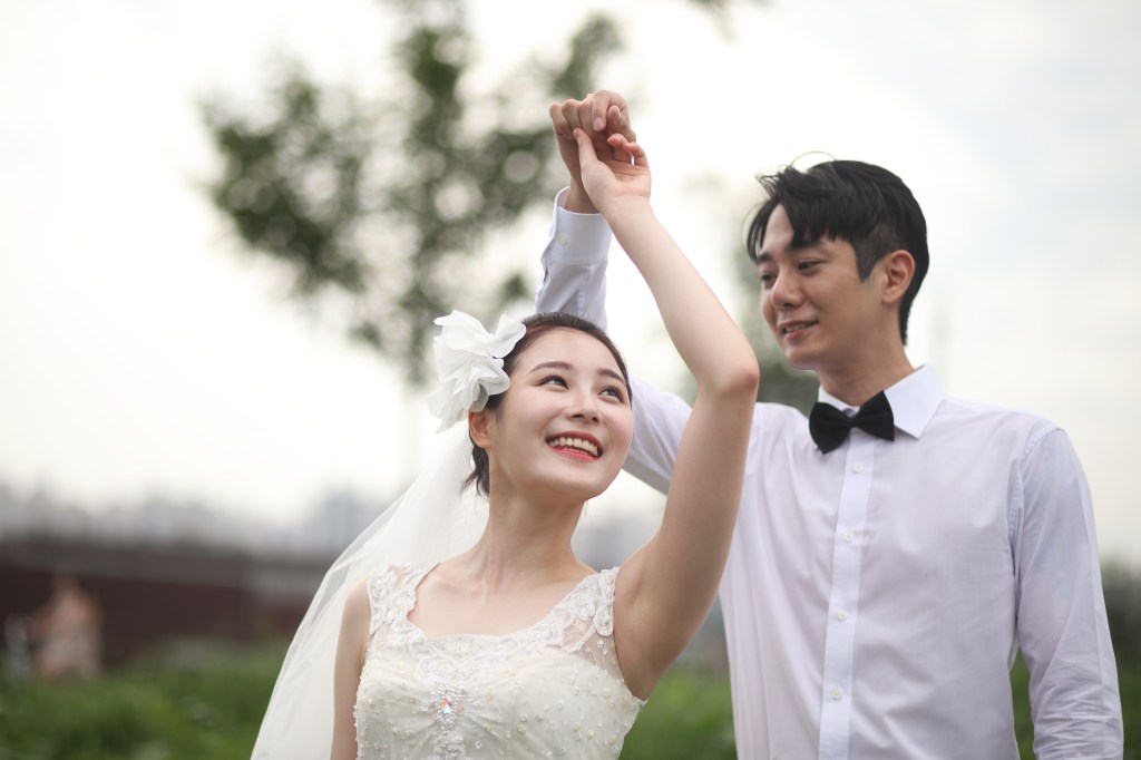Noivos sul-coreanos dançando em uma cerimônia de casamento.
