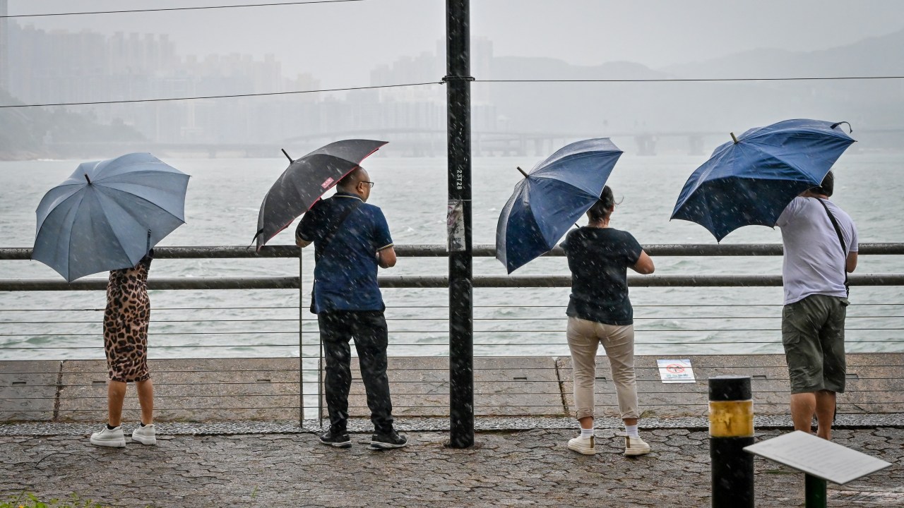 People struggle with their umbrellas in high winds brought by Super Typhoon Saola in Heng Fa Chuen in Hong Kong on September 1, 2023. Super Typhoon Saola threatened southern China on September 1 with some of the strongest winds the region has endured, forcing the megacities of Hong Kong and Shenzhen to effectively shut down. (Photo by Mladen ANTONOV / AFP)