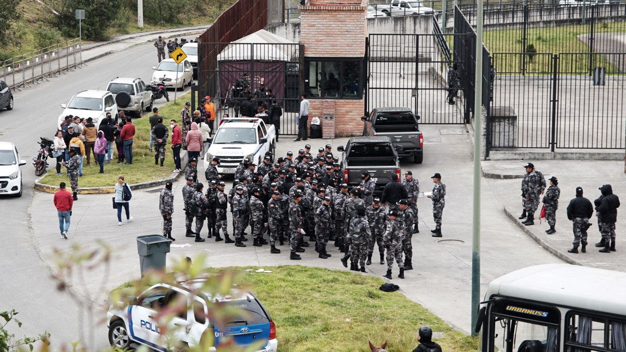 Police officers gather outside the Turi prison in Cuenca, Ecuador on September 1, 2023. Almost 60 prison guards and police officers were being held hostage Friday by inmates across Ecuador. Ecuador's SNAI prisons authority announced Thursday night that 50 prison guards and seven police officers were being held in six different prisons, without giving further details. The news came after two car bombs were detonated near buildings belonging to the prisons authority in Quito the previous evening, with no-one injured. Three grenade explosions also shook the capital. (Photo by Fernando MACHADO / AFP)