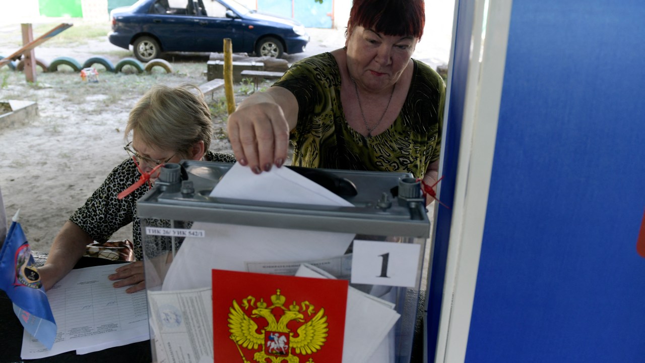 A woman casts her ballot at a mobile polling station during early voting for local elections organised by the Russian-installed authorities in Donetsk, Russian-controlled Ukraine, on September 6, 2023, amid the ongoing conflict between the two countries. (Photo by STRINGER / AFP)