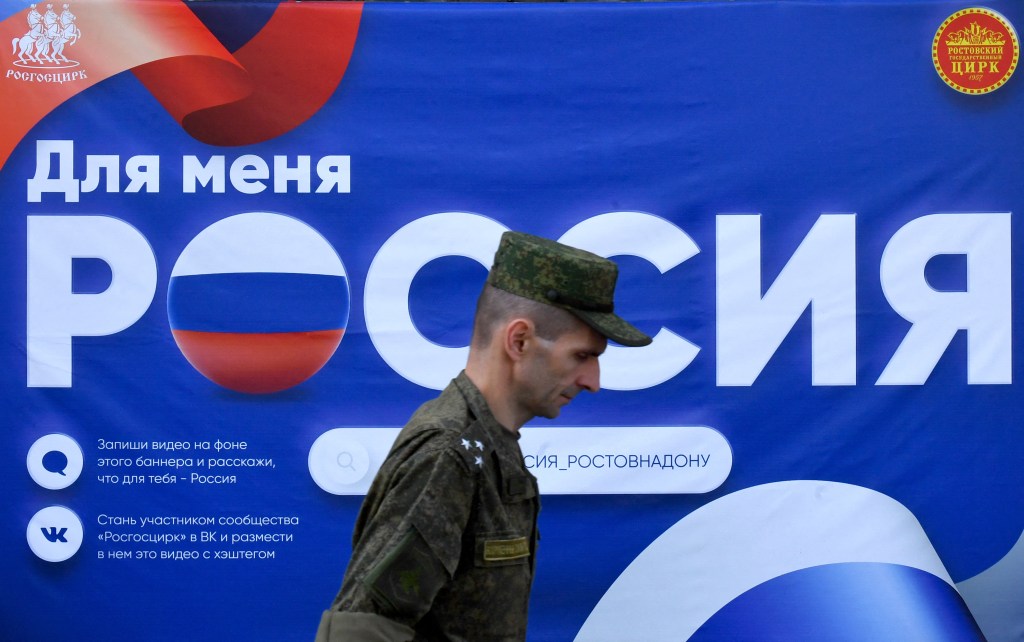 A Russian serviceman walks past a poster reading "Russia" placed in front of a circus in Southern Russian city of Rostov-on-Don on September 7, 2023, prior to Russia's local elections. Prigozhin, good or bad? In Russia, war or no war? In Rostov-on-Don, the short-lived capital of the Wagner group during its mutiny, the paradoxes and unrest within the Russian population are increased tenfold. On the flip side: everything is normal, as the Kremlin assures us. This weekend, local elections are planned in this large city located near the Ukrainian border and logistics center of the Russian army. (Photo by Olga MALTSEVA / AFP)