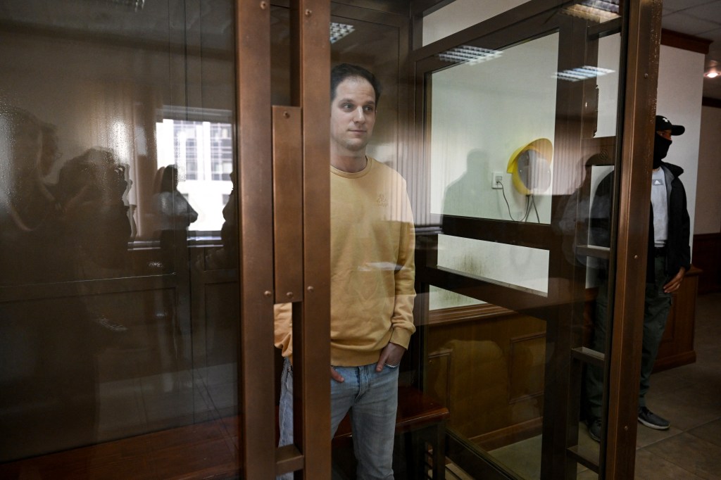 US journalist Evan Gershkovich, arrested on espionage charges, stands inside a defendants' cage before a hearing to consider an appeal on his extended pre-trial detention at the Moscow City Court in Moscow on September 19, 2023. Gershkovich was detained in March during a reporting trip to the Urals and accused of spying -- charges that he, the US government and his employer, the Wall Street Journal, vehemently deny. In August his pre-trial detention was extended by three months. (Photo by NATALIA KOLESNIKOVA / AFP)