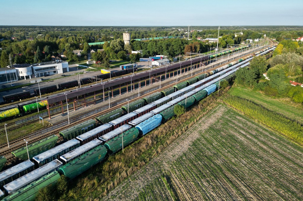 This picture taken on September 20, 2023 shows trains with Ukrainian grain stored in wagons covered with white tarpaulin on the second and third tracks in Dorohusk station at the Polish-Ukrainian border. Poland's Prime Minister Mateusz Morawiecki on September 20, 2023 cautioned that the EU member would ban additional Ukrainian imports if Kyiv were to escalate their conflict over a grain embargo. (Photo by Damien SIMONART / AFP)