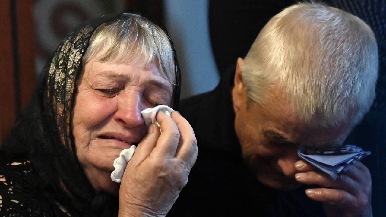 Relatives reacts next to a coffin containing the body of slain Ukrainian serviceman Sergiy Radyuk during his funeral service in St. Michael's Golden-Domed cathedral in Kyiv on September 25, 2023, amid Russian invasion in Ukraine. (Photo by Sergei SUPINSKY / AFP)