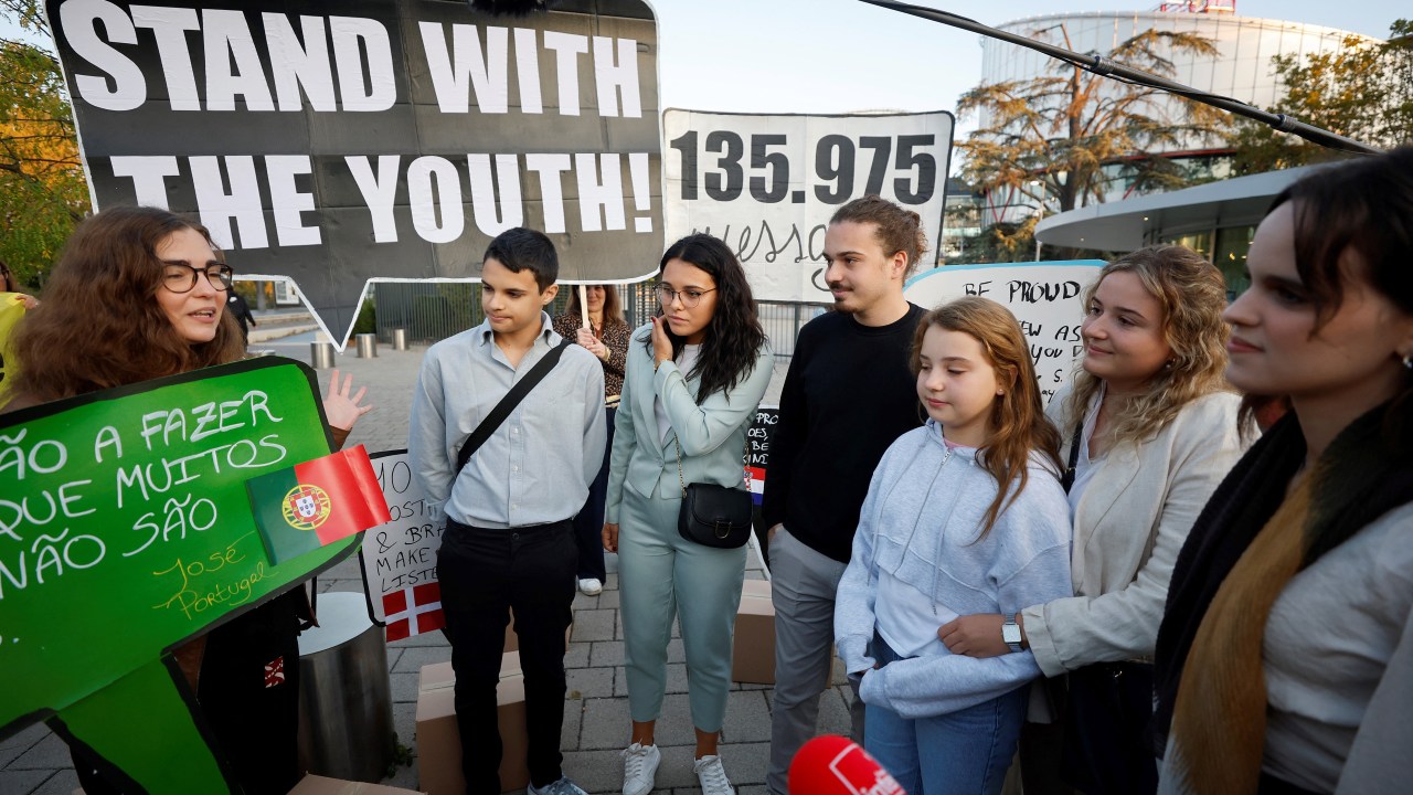 Young Portuguese citizens hold placards as they arrive at the European Court of Human Rights (ECHR) for a hearing in a climate change case involving themselves against 32 countries, in Strasbourg, eastern France, on September 27, 2023. The European Court of Human Rights (ECHR) on September 27, 2023, began hearing a case brought by six Portuguese youths against 32 nations for not doing enough to stop global warming, the latest bid to secure climate justice through the courts. (Photo by FREDERICK FLORIN / AFP)