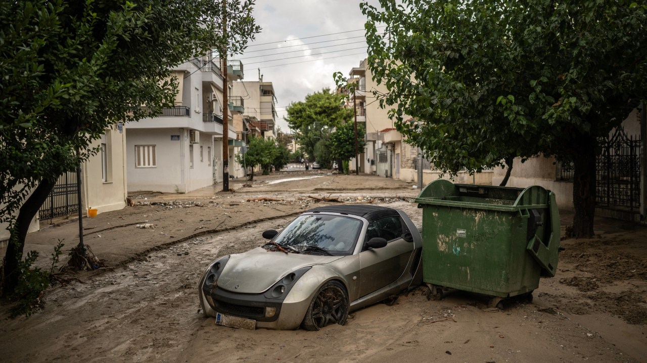 This photograph taken on September 28, 2023 shows a car on a muddy street after the Storm Elias at Volos. Hundreds of people were rescued from floods in Greece overnight and early on September 28, 2023, officials said, as a new storm hit the country just weeks after floods left 17 dead. The fire service said it had assisted over 250 people in the region surrounding the central city of Volos, where a curfew was declared September 27, 2023, as Storm Elias made landfall. (Photo by Angelos TZORTZINIS / AFP)