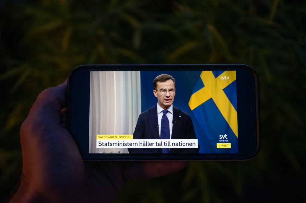 Picture taken on September 28, 2023 in Sundbyberg, near Stockholm shows a live broadcast of Swedish Prime Minister, Ulf Kristersson as he addresses the nation regarding the last wave of criminal acts in Sweden. For years now, Sweden has been in the grip of a war between gangs fighting over arms and drug trafficking, involving firearms and explosive devices. (Photo by Jonathan NACKSTRAND / AFP)