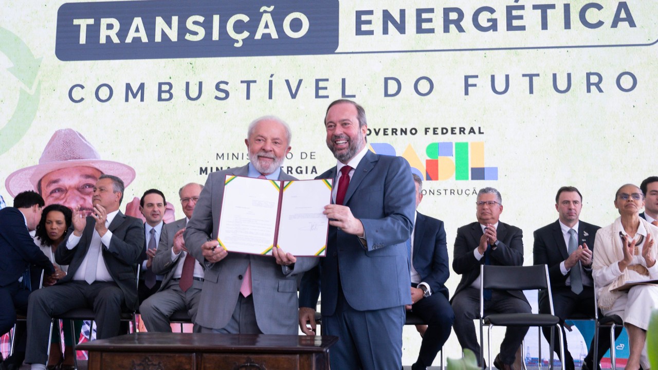 O presidente Lula assina ao lado do ministro de Minas e Energia, Alexandre Silveira