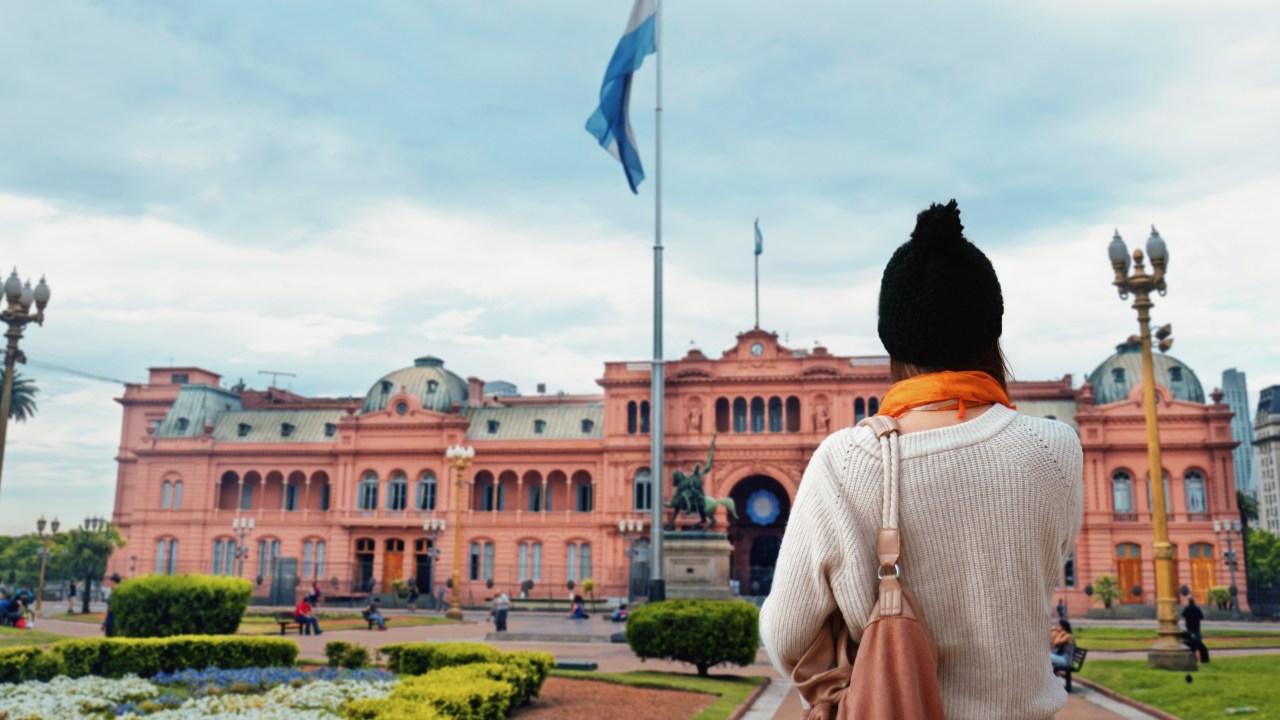 Uma jovem turista andando na Plaza de Mayo, em Buenos Aires, Argentina.