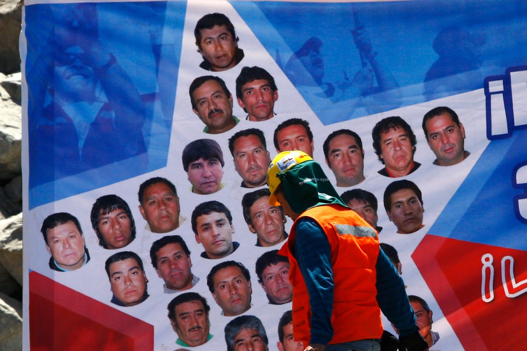 Uma equipe de resgate passa por uma faixa com mensagens para mineiros presos na mina de San Jose, em Copiapó, no Chile. 11/10/2010