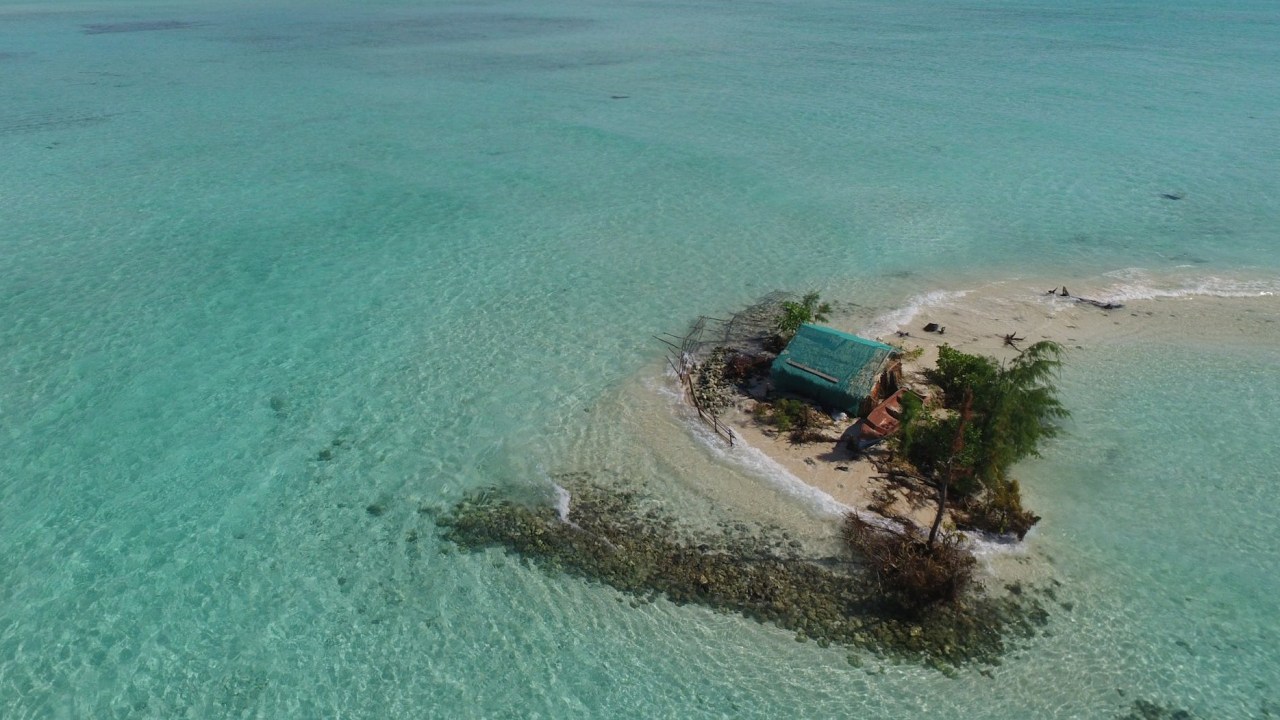 Neste pequeno atol nas lhas Salomão, o oceano batendo à porta da pequena casa ilustra a situação desesperadora dos países-arquipélagos ao redor do mundo.