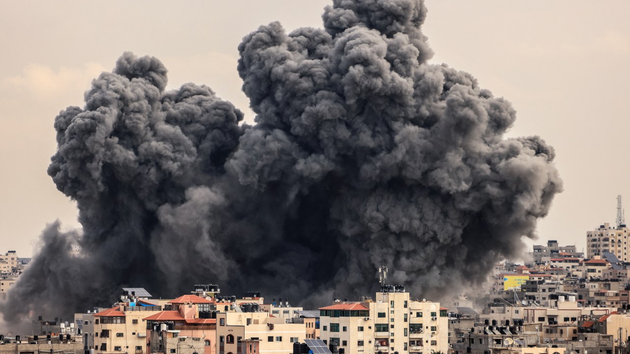 A plume of smoke rises in the sky of Gaza City during an Israeli airstrike on October 9, 2023. Israel relentlessly pounded the Gaza Strip overnight and into October 9 as fighting with Hamas continued around the Gaza Strip, as the death toll from the war against the Palestinian militants surged above 1,100. (Photo by MAHMUD HAMS / AFP)