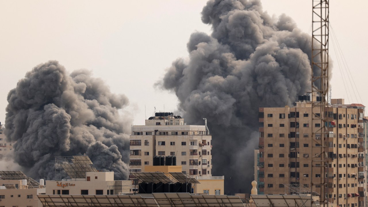 A black plume of smoke billows behind highrise buildings in the sky during an Israeli airstrike on Gaza City on October 9, 2023. Israel relentlessly pounded the Gaza Strip overnight and into October 9 as fighting with Hamas continued around the Gaza Strip, as the death toll from the war against the Palestinian militants surged above 1,100. (Photo by MAHMUD HAMS / AFP)