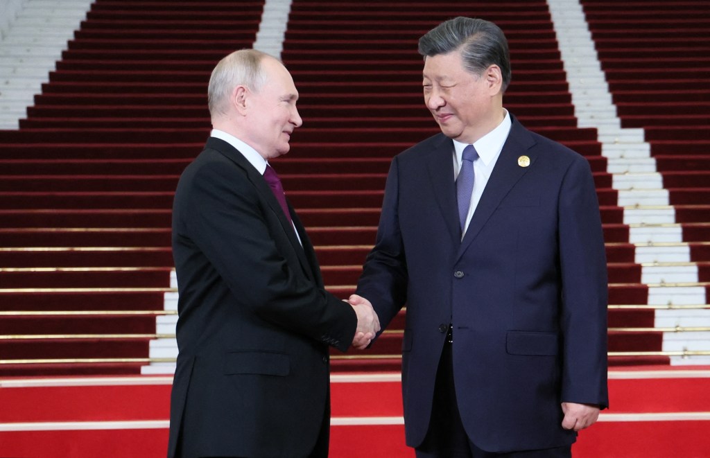 This pool photograph distributed by Russian state owned agency Sputnik shows Russia's President Vladimir Putin and Chinese President Xi Jinping shaking hands during a welcoming ceremony at the Third Belt and Road Forum in Beijing on October 17, 2023. (Photo by Sergei SAVOSTYANOV / POOL / AFP)