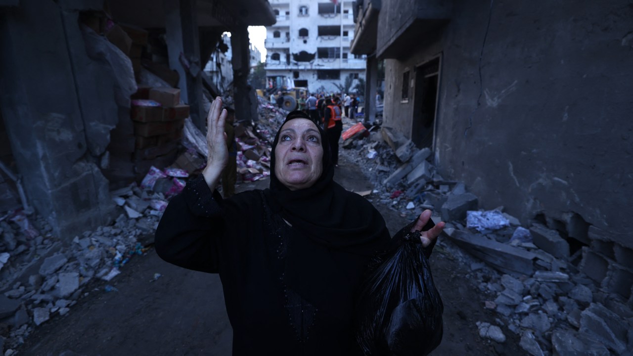 A Palestinian reacts amidst the rubble of a building after an Israeli airstrike on the Rafah refugee camp, in the southern Gaza Strip on October 17, 2023. Relief convoys which have been waiting for days in Egypt were on October 17, headed towards the Rafah border crossing with the besieged Palestinian enclave of Gaza, aid officials said. (Photo by MOHAMMED ABED / AFP)