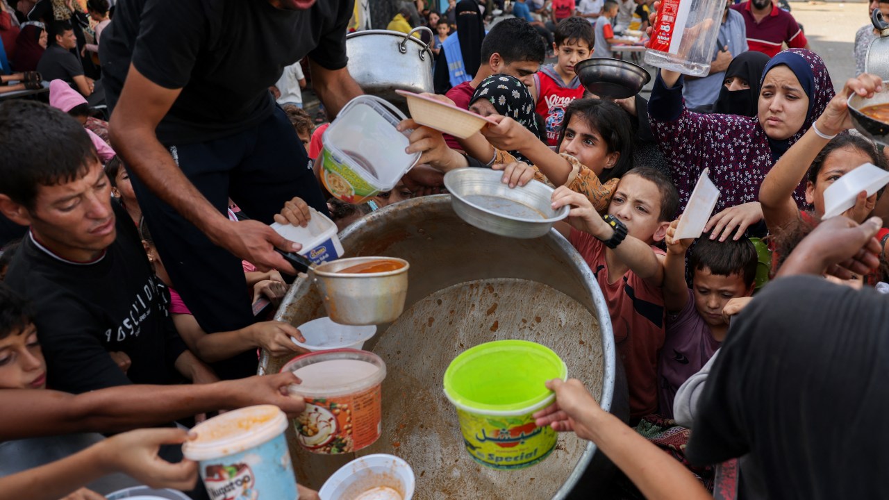 Palestinian children receive food at a UN-run school in Rafah, on the southern Gaza Strip on October 23, 2023 amid ongoing battles between Israel and Hamas militants. (Photo by MOHAMMED ABED / AFP)