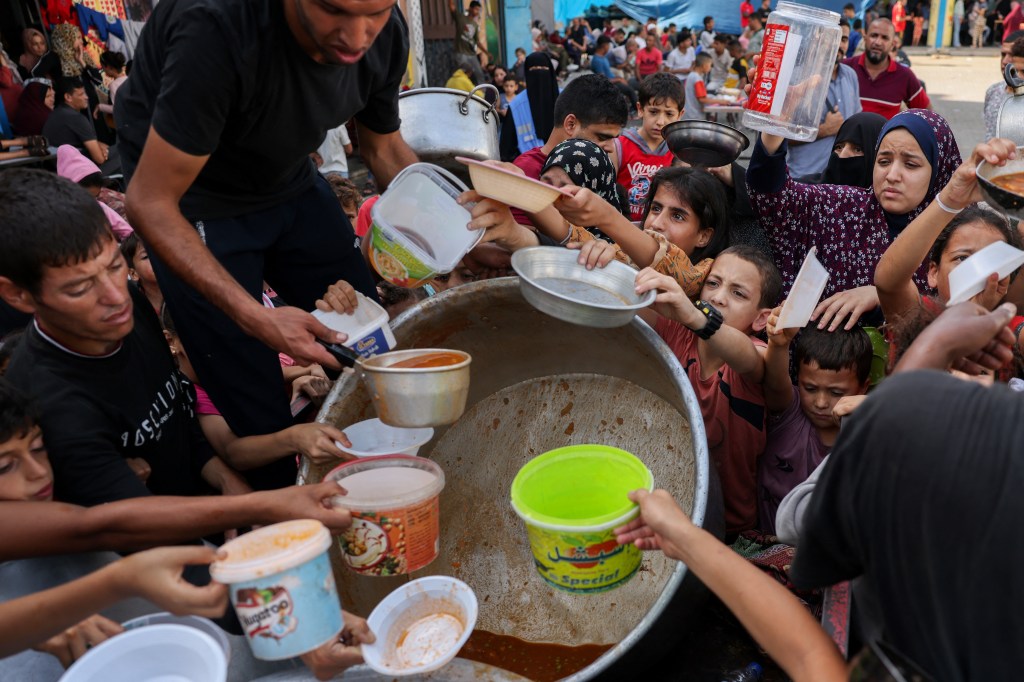 Palestinian children receive food at a UN-run school in Rafah, on the southern Gaza Strip on October 23, 2023 amid ongoing battles between Israel and Hamas militants. (Photo by MOHAMMED ABED / AFP)