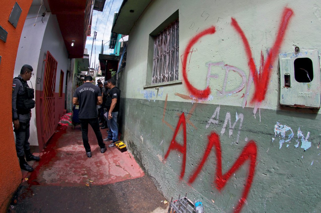 RASTRO DE SANGUE - Homem morto ao lado de pichação alusiva ao Comando Vermelho em Manaus: guerra de facções
