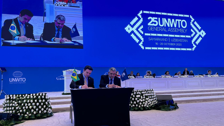 O ministro do Turismo, Celso Sabino, e o secretário-geral da Organização Mundial do Turismo, Zurab Pololikashvili, assinam acordo durante a 25ª Assembleia Geral da entidade da ONU, no Uzbequistão