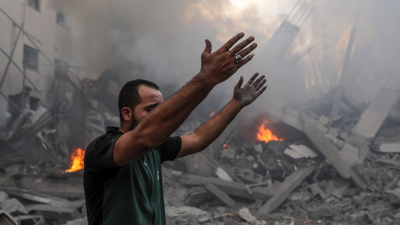 Um homem palestino em meio aos escombros em Gaza.