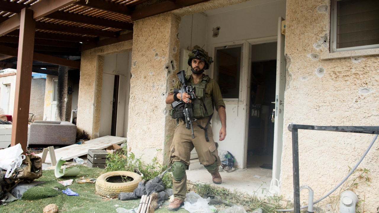 Soldado israelense sai de uma casa destruída após um ataque do Hamas perto da fronteira com Gaza, em Kfar Aza, Israel. 10/10/2023