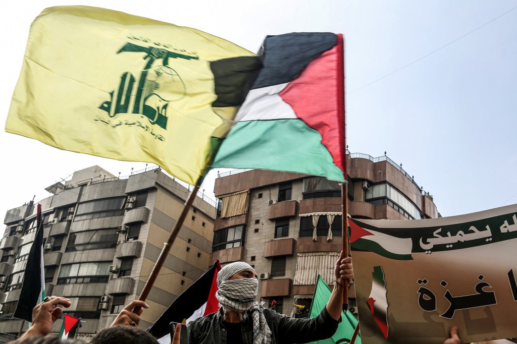 Manifestantes libaneses carregam bandeiras do Hezbollah e da Palestina. 13/10/2023