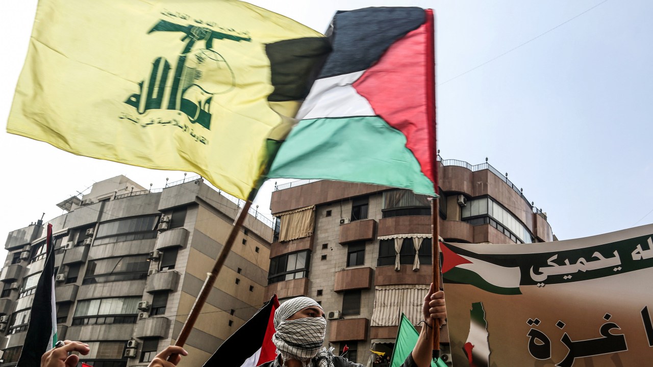 Manifestantes libaneses carregam bandeiras do Hezbollah e da Palestina. 13/10/2023