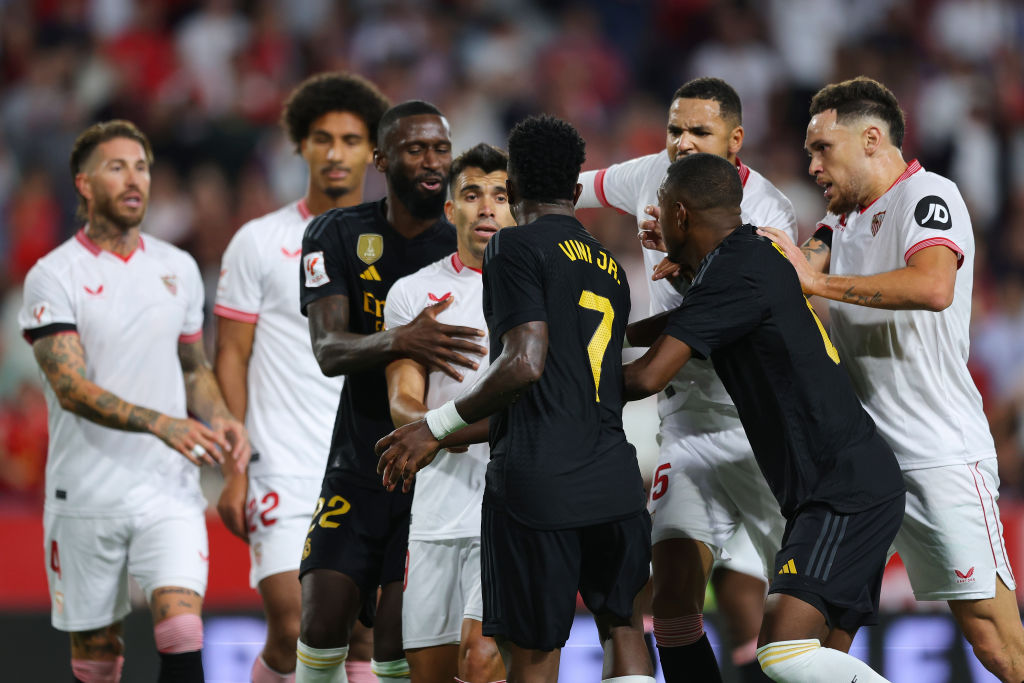 SEVILLE, SPAIN - OCTOBER 21: Vinicius Junior of Real Madrid clashes with Sevilla FC players during the LaLiga EA Sports match between Sevilla FC and Real Madrid CF at Estadio Ramon Sanchez Pizjuan on October 21, 2023 in Seville, Spain. (Photo by Fran Santiago/Getty Images)