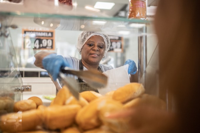 Employee getting some bread to customer in a bakery