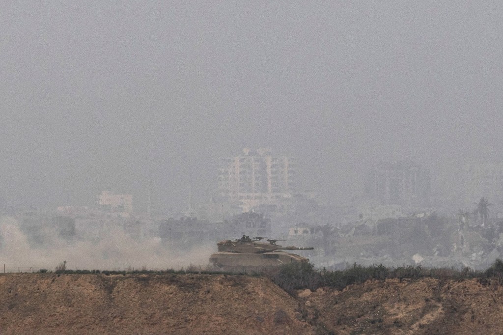 Um tanque de guerra israelense desfila pelo território sitiado de Gaza.