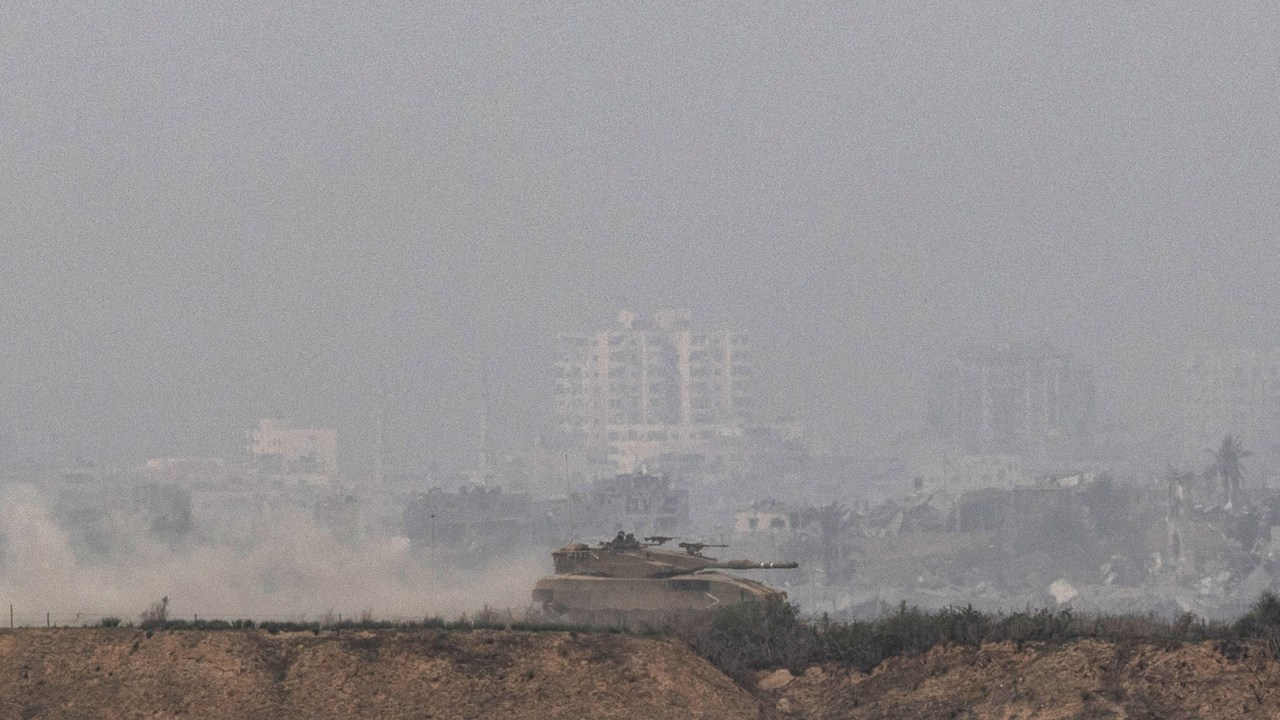 Um tanque de guerra israelense desfila pelo território sitiado de Gaza.