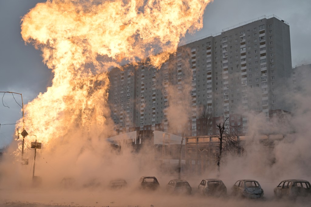 Incêndio e carros queimados são vistos em Kiev após um ataque russo com mísseis, em meio à guerra na Ucrânia. 02/01/2024