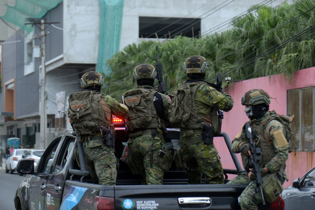 Ecuadorean security forces enter the premises of Ecuador's TC television channel after unidentified gunmen burst into the state-owned television studio live on air on January 9, 2024, in Guayaquil, Ecuador, a day after Ecuadorean President Daniel Noboa declared a state of emergency following the escape from prison of a dangerous narco boss. Gunshots rang out on live TV in violence-torn Ecuador as armed men carrying rifles and grenades stormed the studio shortly after gangsters vowed a "war" against the president's plans to reclaim control from "narcoterrorists". (Photo by STRINGER / AFP)