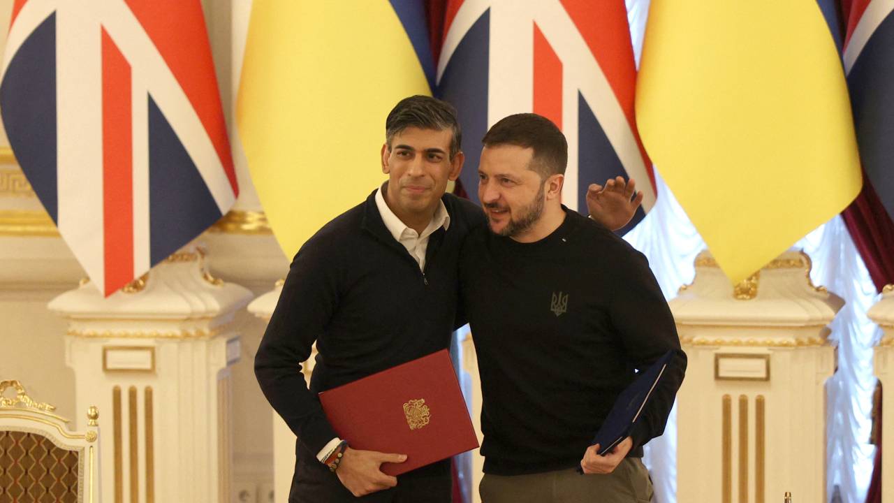 O presidente da Ucrânia, Volodymyr Zelensky, e o primeiro-ministro do Reino Unido, Rishi Sunak, se abraçam após assinarem documentos após seu encontro em Kiev. (12/01/2022)