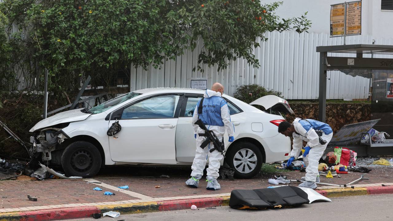Israeli police forensics personnel inspect a damaged car following a suspected ramming attack in the central town of Raanana, on January 15, 2024. (Photo by JACK GUEZ / AFP)