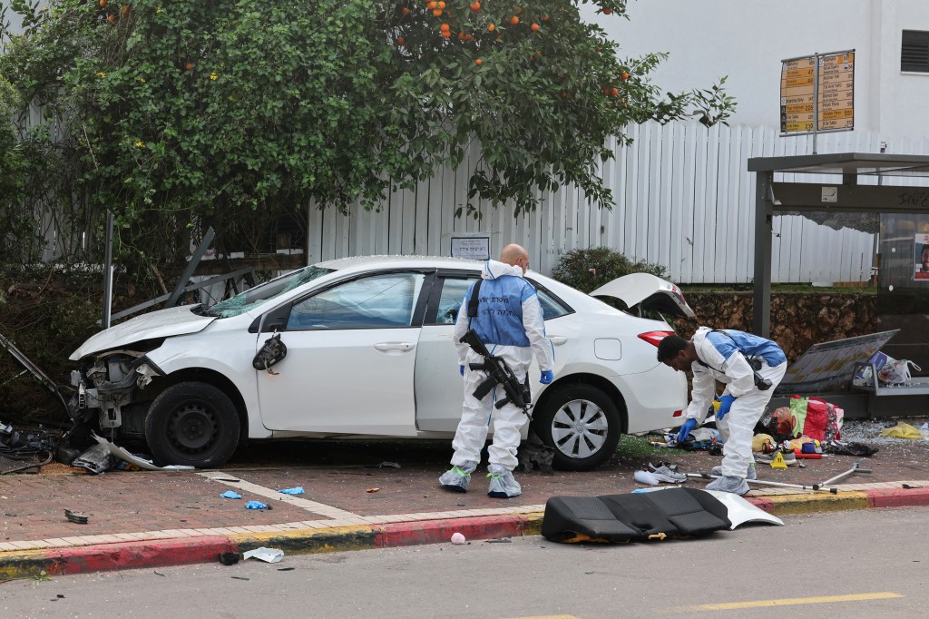 Israeli police forensics personnel inspect a damaged car following a suspected ramming attack in the central town of Raanana, on January 15, 2024. (Photo by JACK GUEZ / AFP)