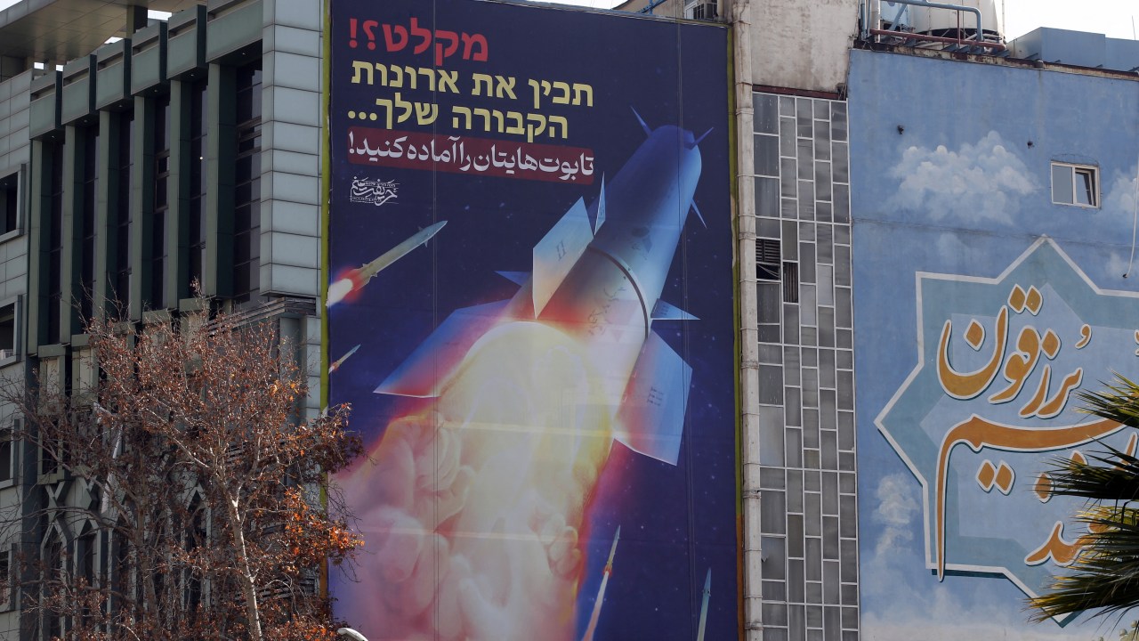 A large billboard depicting Iranian missiles with writing in Hebrew and in Persian which reads 'prepare your coffins', hangs on the side of a building in Tehran on January 16, 2024, after Iran's overnight missile attacks on multiple targets in Syria and in Iraq's autonomous Kurdistan region. Iran defended its strikes on January 16, saying they were a "targeted operation" and "just punishment" against those who breach the Islamic republic's security. (Photo by AFP)